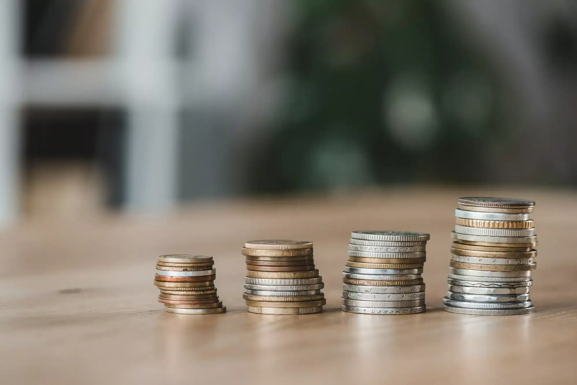 Stacks of coins on wooden tabletop in financial office