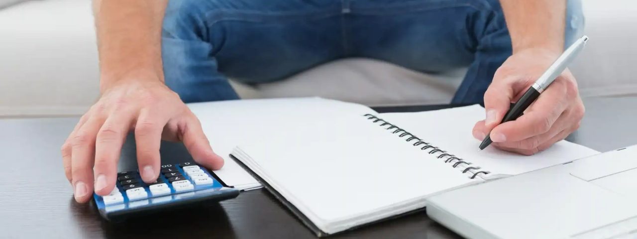 A businessman working on his finances at a table at his home