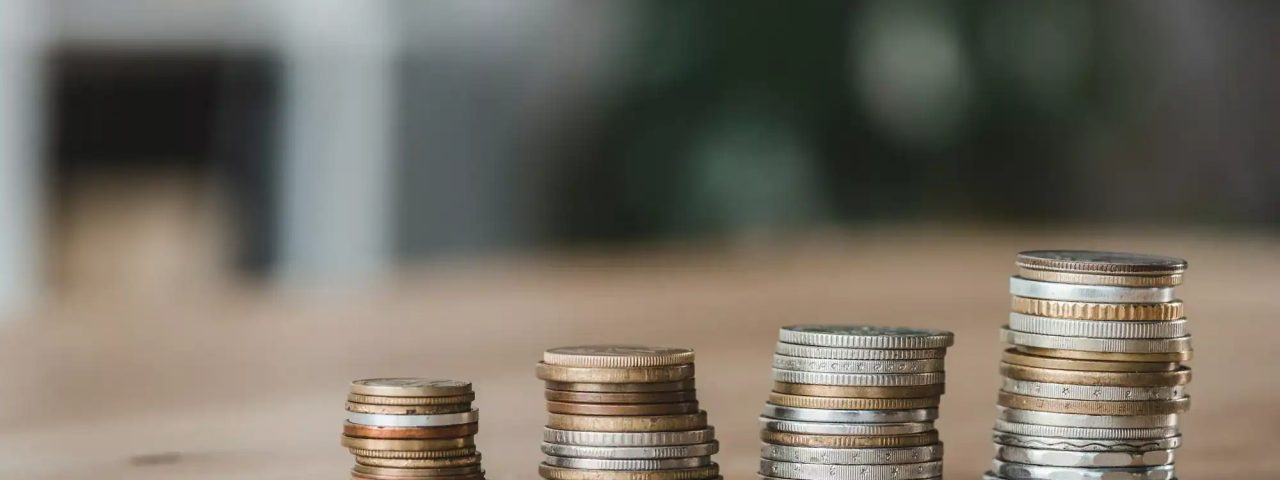 Stacks of coins on wooden tabletop in financial office