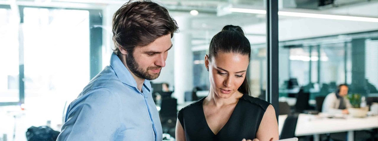 Young businesspeople with tablet in an office, working