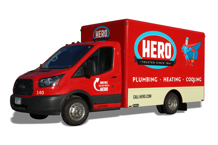 A red Hero service van with a cartoon superhero and "Plumbing, Heating, Cooling" printed on the side, parked facing left.