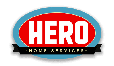 Logo for Hero Home Services featuring the word "HERO" in bold white letters on a red oval with a blue border, resembling an Imported Kit badge, and a black ribbon below displaying "HOME SERVICES.