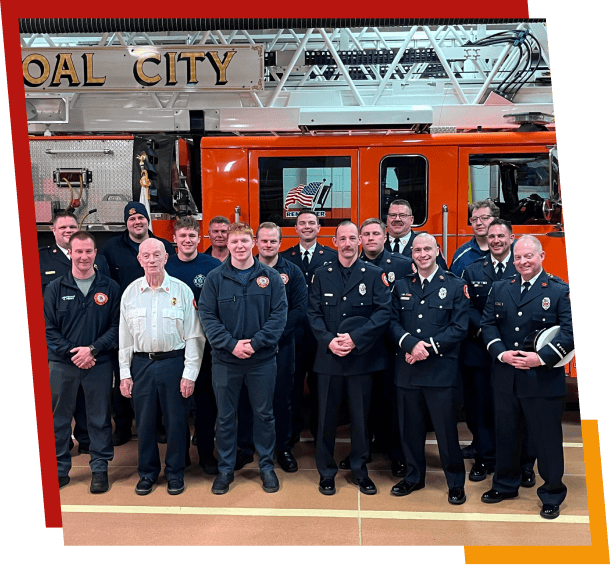 Group of firefighters posing in front of fire truck