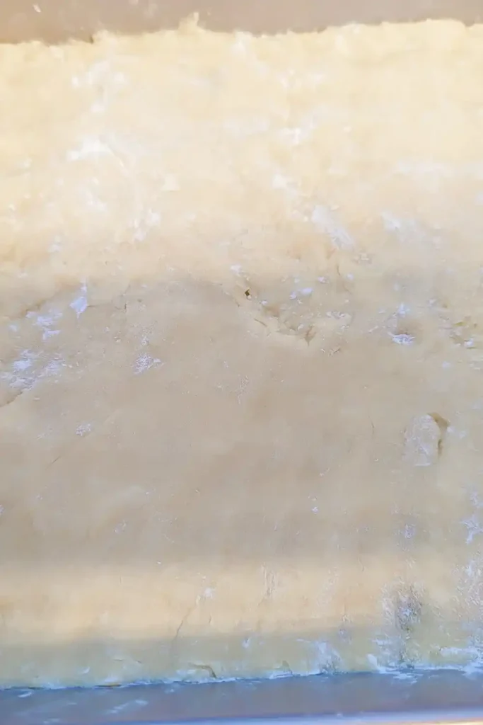 pressing the crumble bar dough into eight by eight baking pan