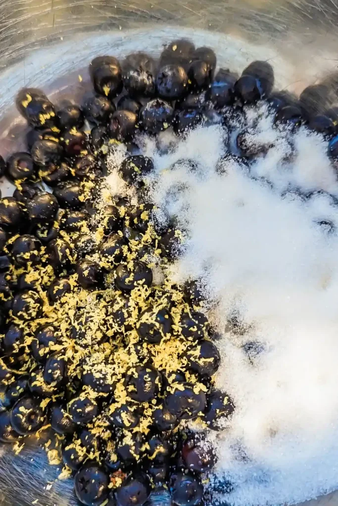 adding white sugar to lemon and blueberry