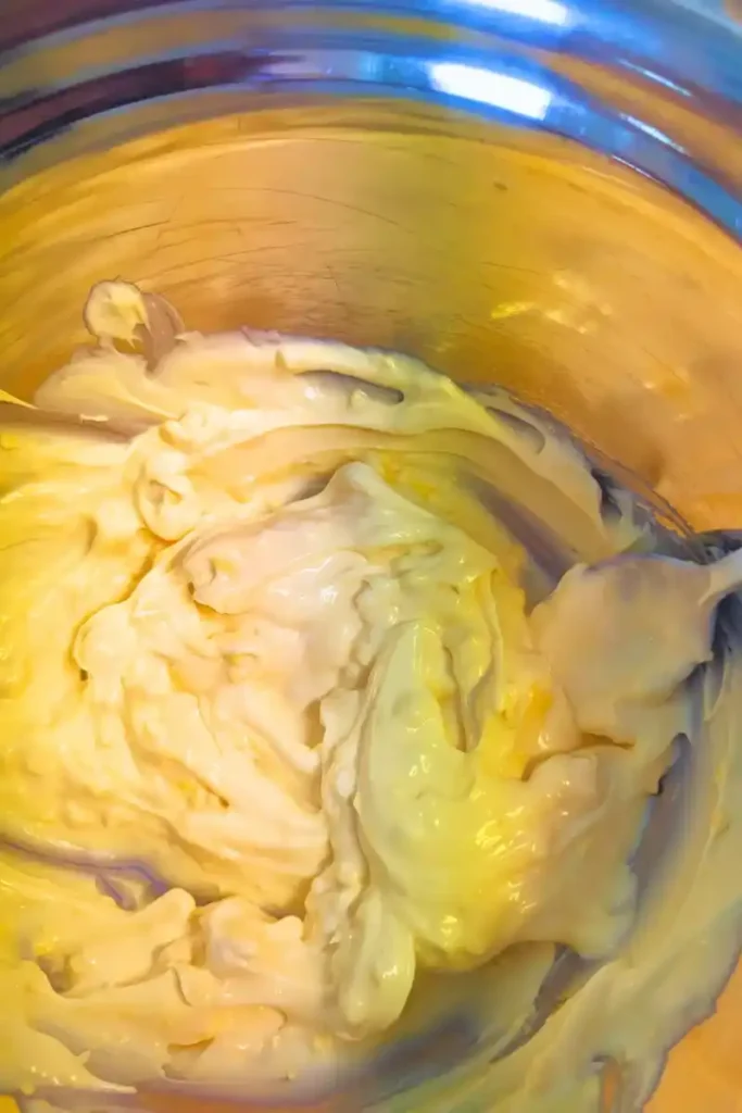 mixing egg yolks into mayonnaise