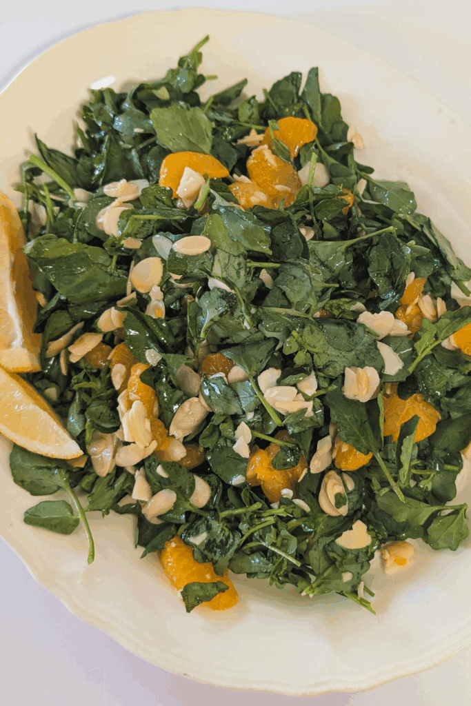 plated watercress salad with lemon wedge garnish