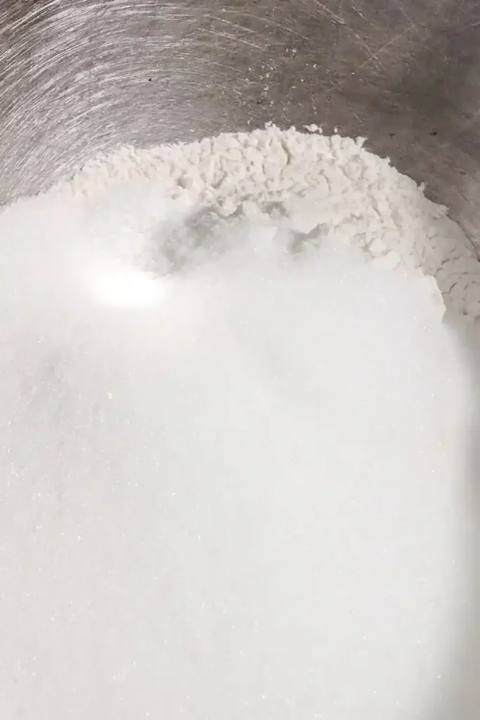 adding sugar and baking powder as well as salt to the flour