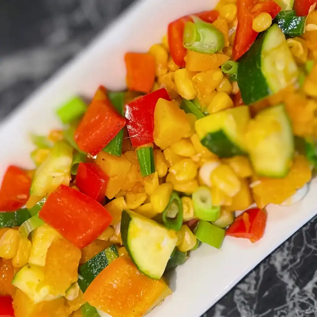 Succotash with Zucchini and Butternut Squash side view white plate on angle kiddy corner to corner
