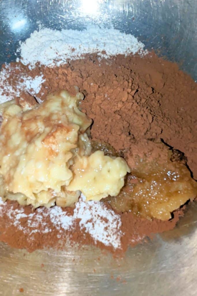 adding mashed banana and honey to eggless chocolate brownies