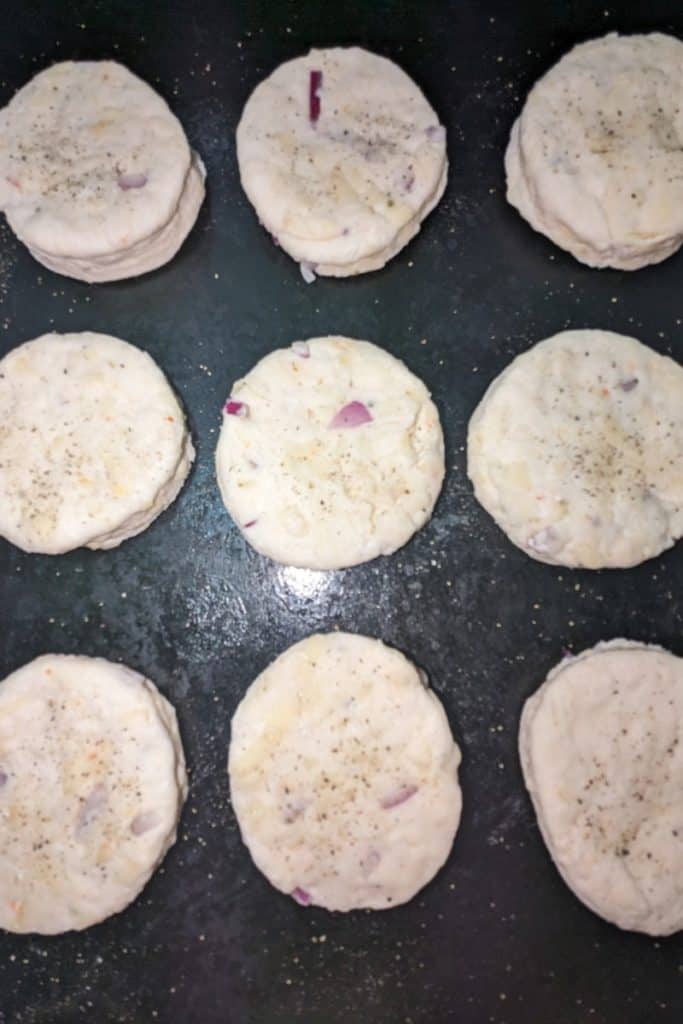 sprinkle tops of jalapeno havarti cheese biscuit dough rounds with black pepper