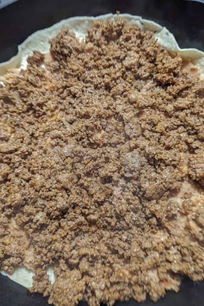 add a layer of taco meat on top the refried beans