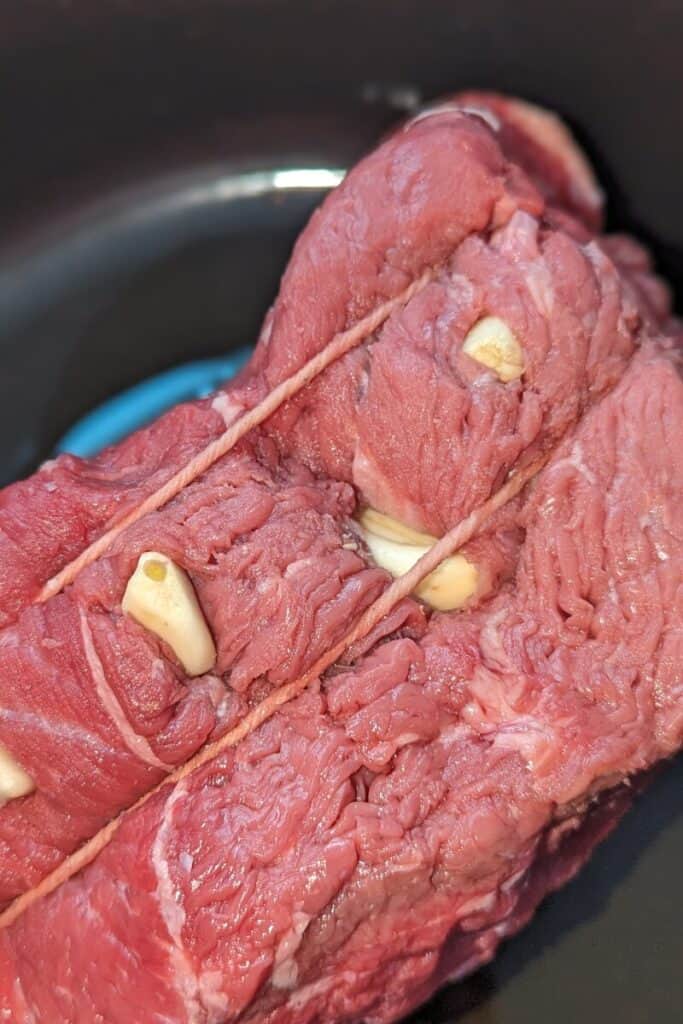 Shove whole cloves of garlic into roast beef