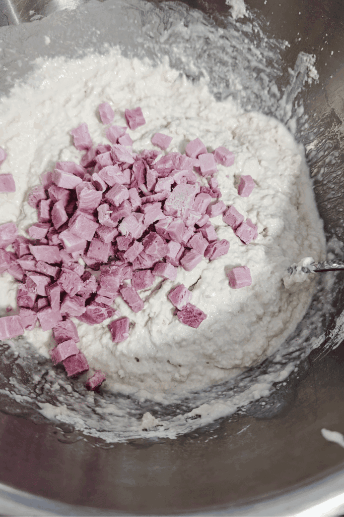 adding bits of ham to bread dough