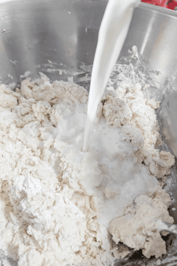 adding milk to rough bread dough
