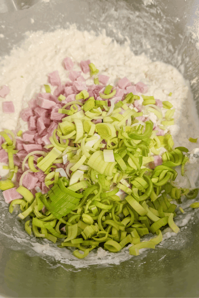 adding the leeks to the ham and dough