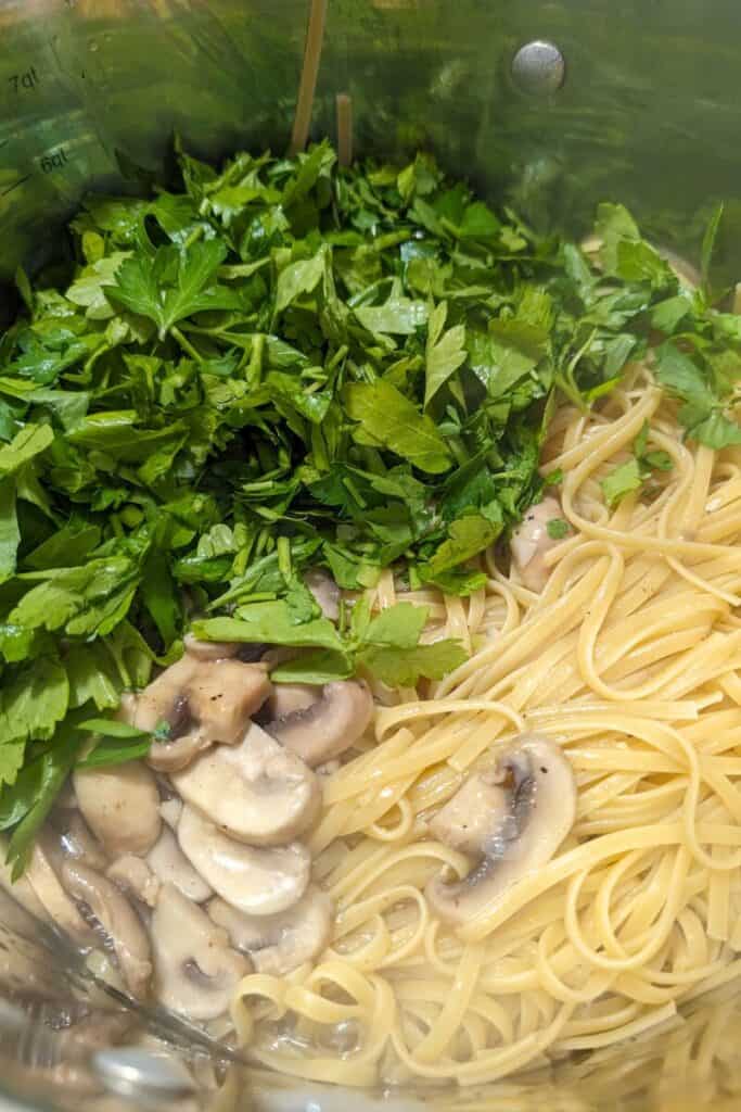 adding fresh parsley to Mushroom linguine
