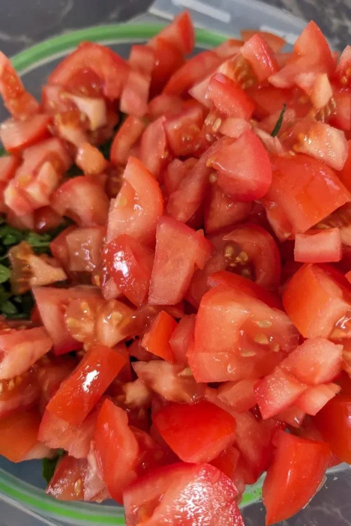 adding chopped tomato to salad