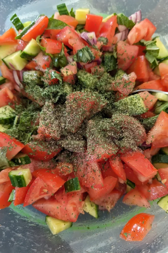 adding fresh basil to salad with cucumber