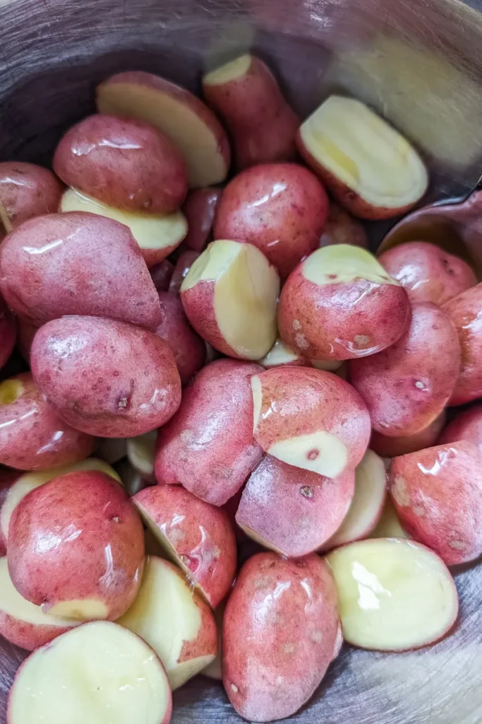 adding olive oil to baby potatoes