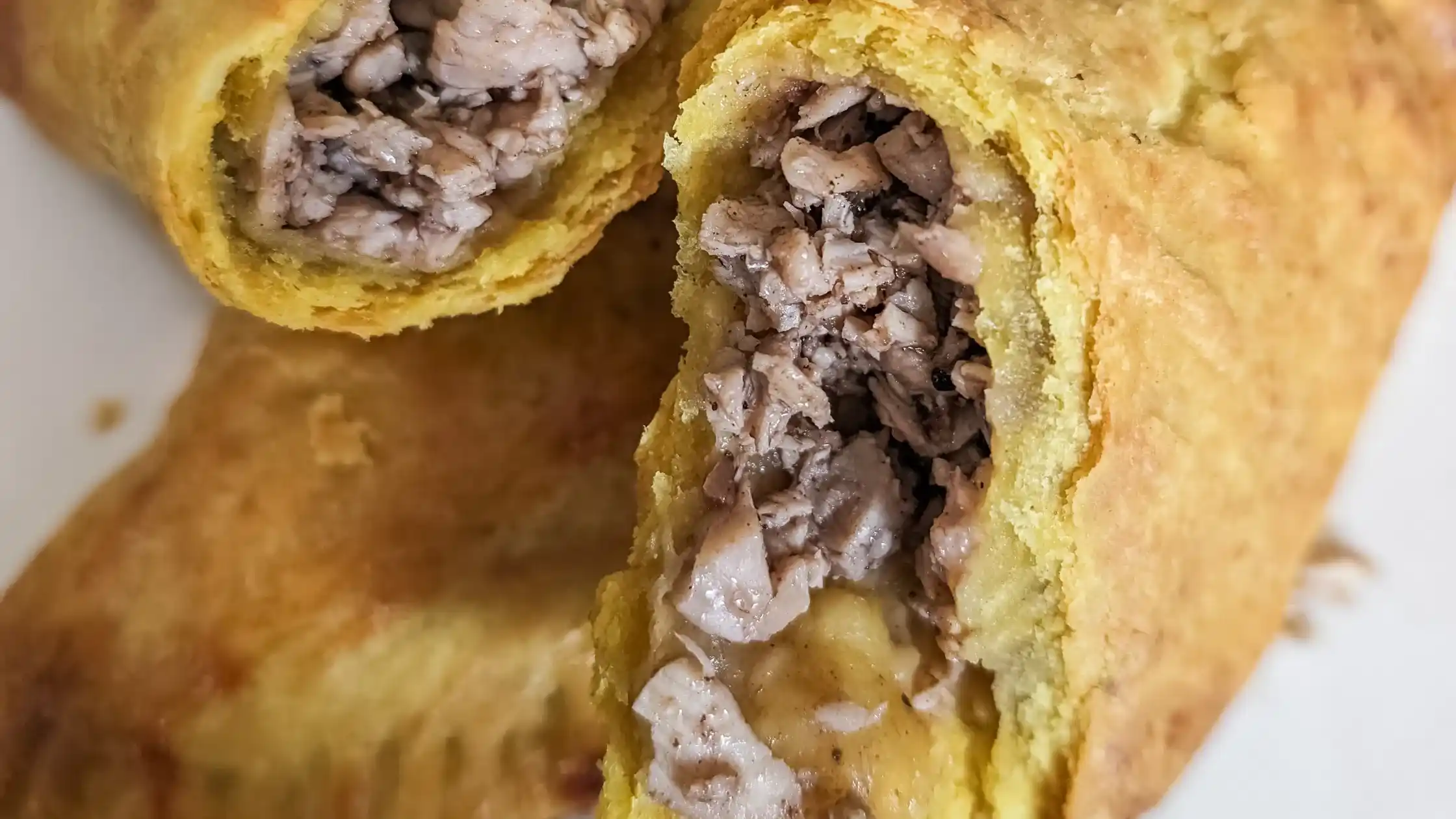 fully cooked Jerk chicken Jamaican patties opened up close