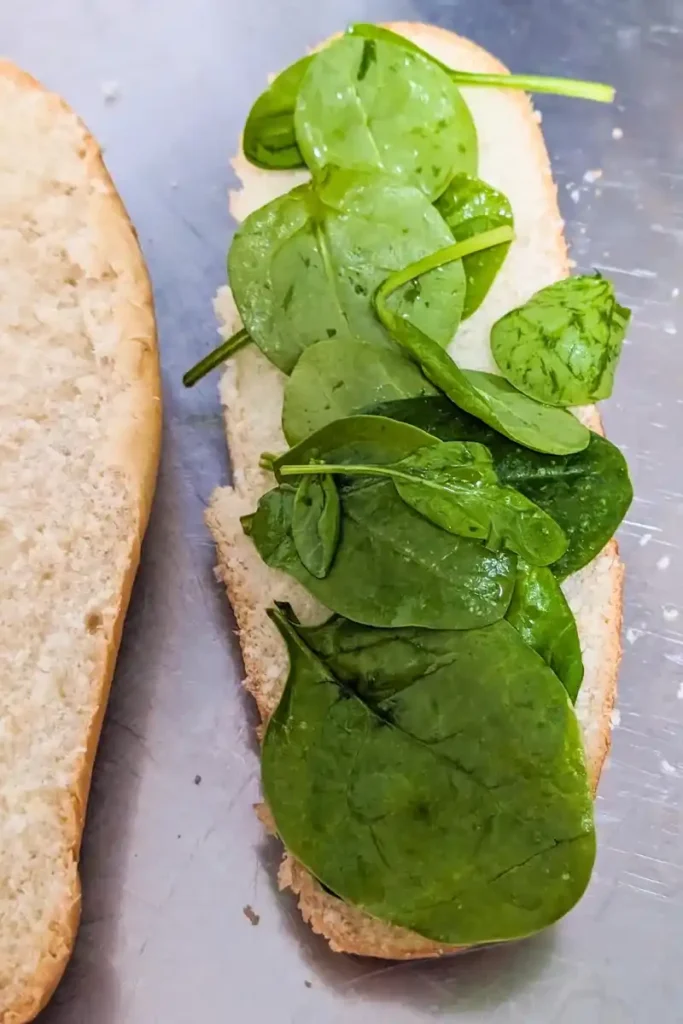 adding spinach to sandwich