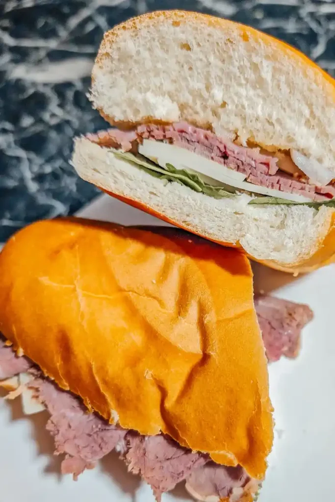 the roast beef sub cut in half on white plate