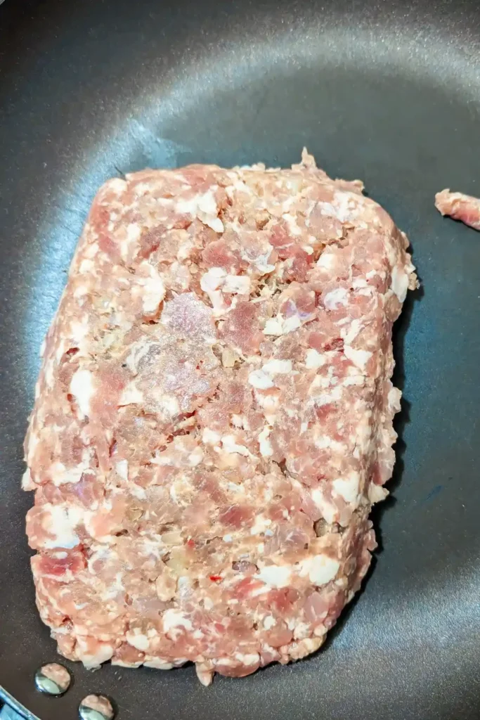 ground garlic sausage meat in fry pan