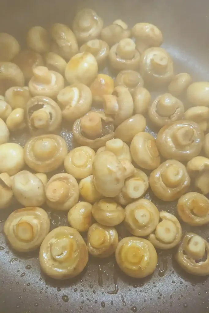 cooking the button mushrooms until golden