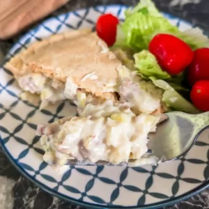 recipe care image of slice of pie with some on fork and side salad