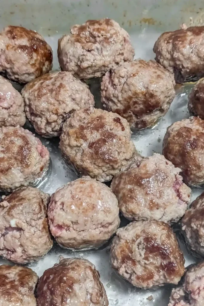 the browned meatballs in glass baking dish