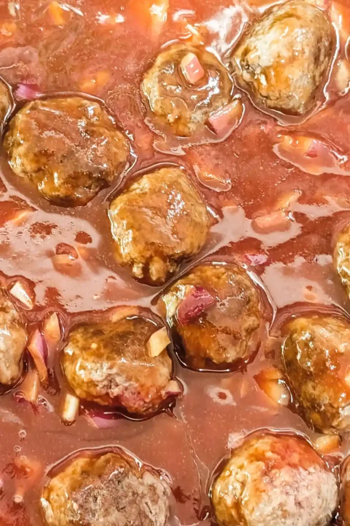 covering the browned meatballs with the bbq sauce mixture