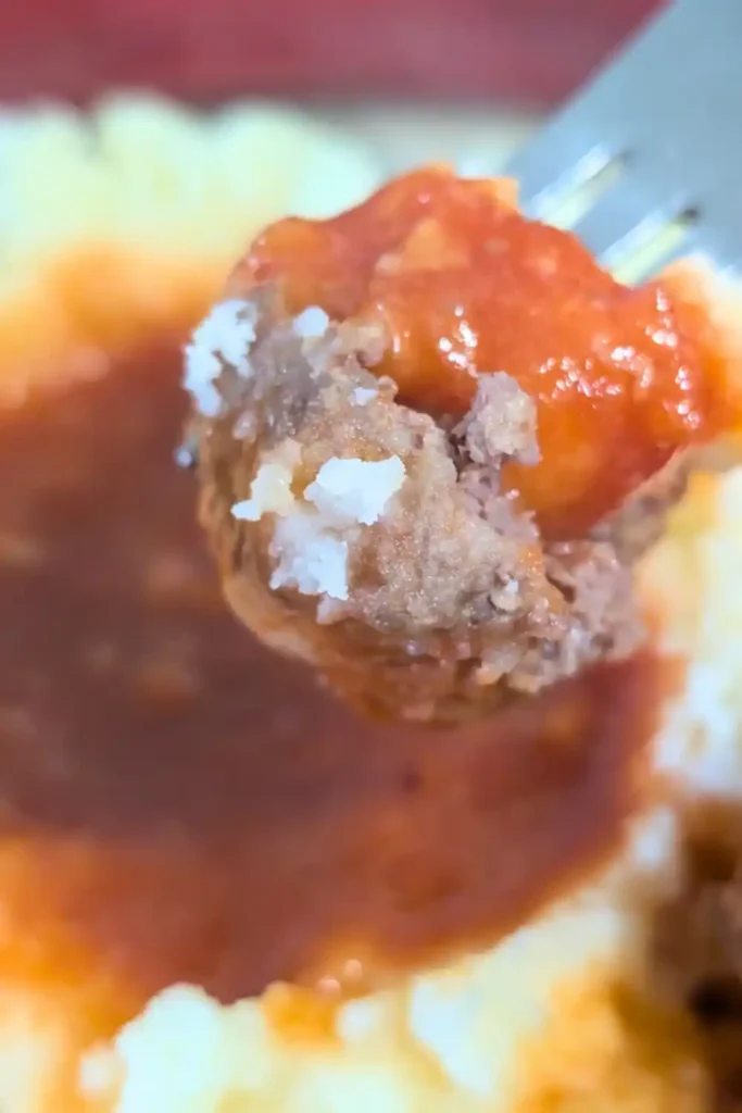 dipping a meatball into the bbq sauce in the mashed potato well.