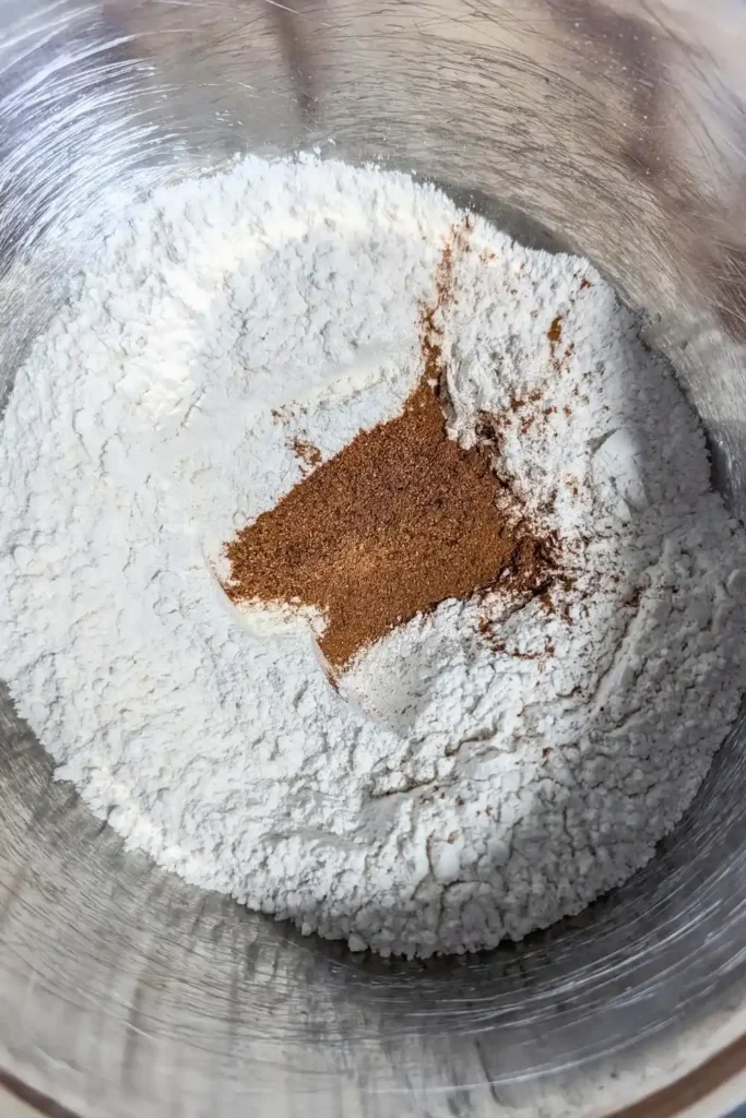 adding cinnamon and nutmeg to donuts