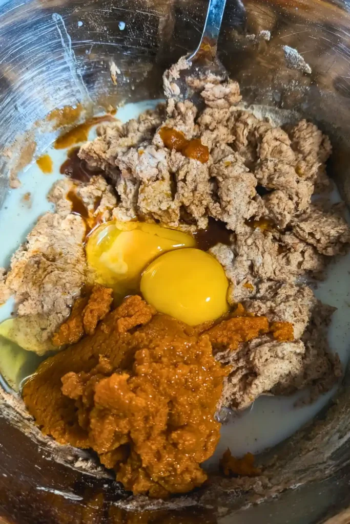 adding eggs and pumpkin to batter