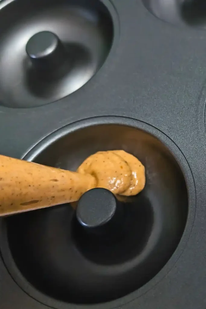 using piping bag in donut pan