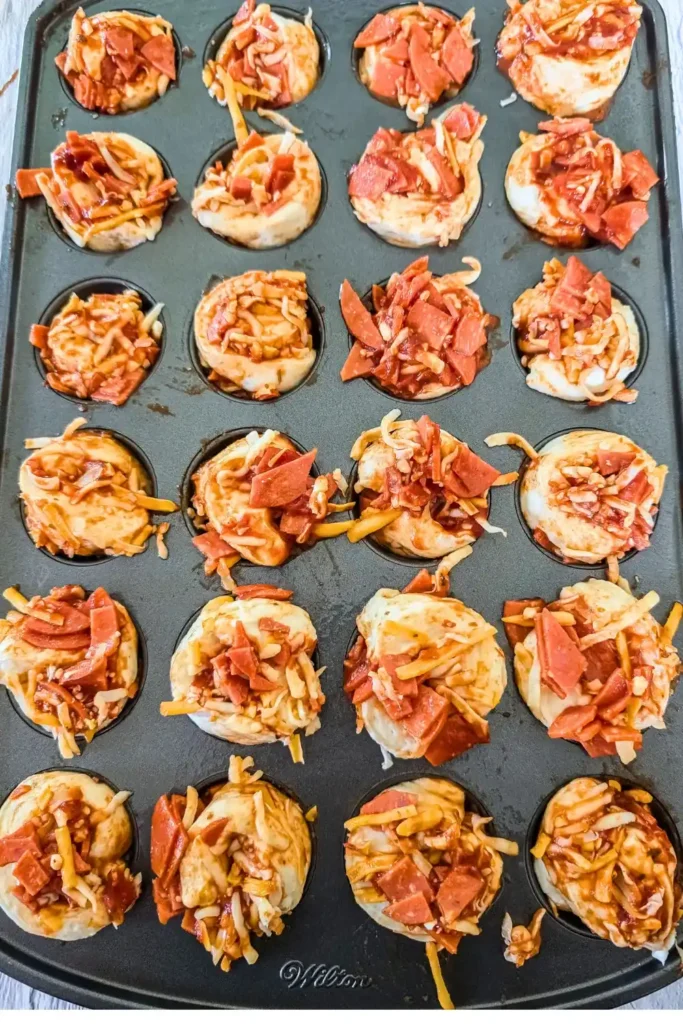 rolled pizza in Wilton mini muffin pan ready to bake