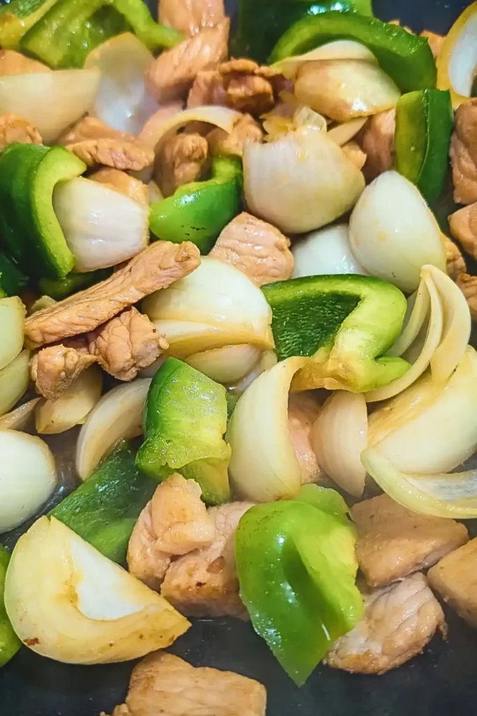 the green peppers and onions cooking with the pork for the stir fry in wok
