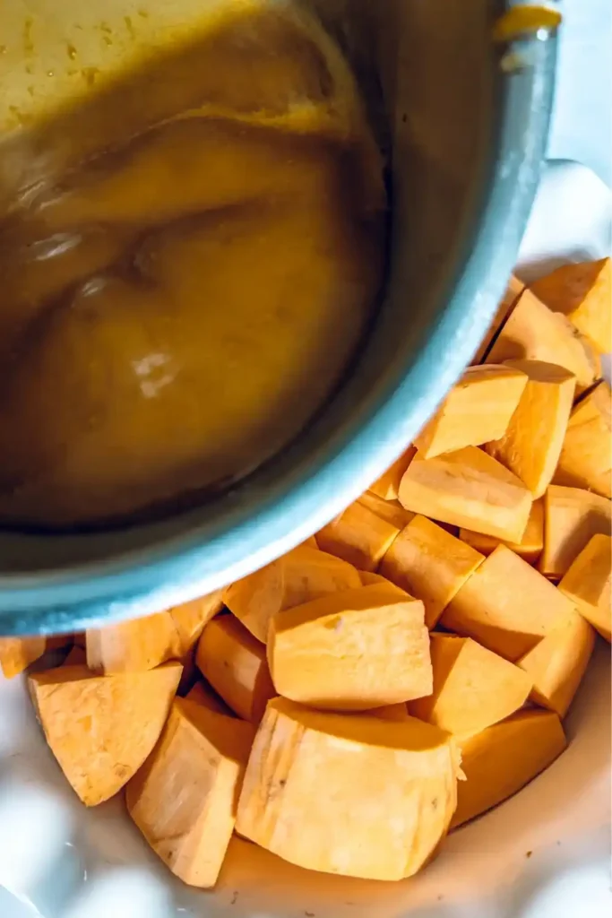 pouring orange sauce over sweet potatoes