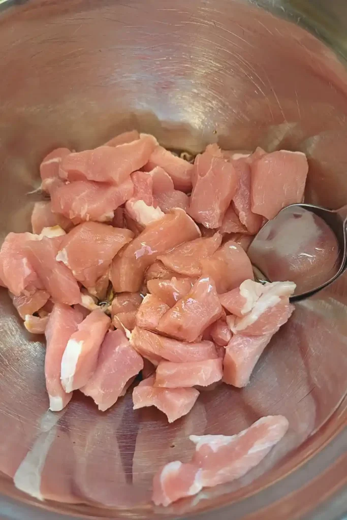 adding oil and soya sauce to pork pieces