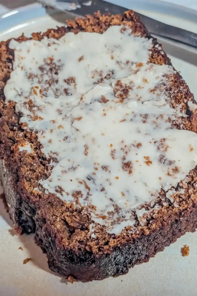 buttered thick slice of gingerbread on cake with butterknife