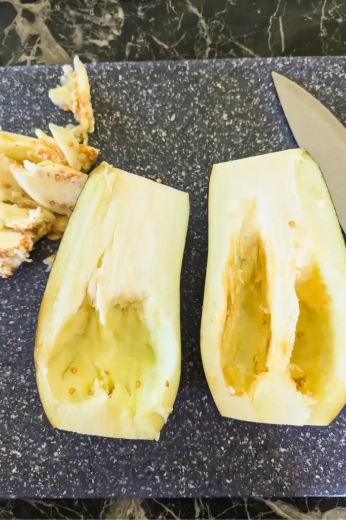 eggplant with seeds and pulp scooped out on cutting board