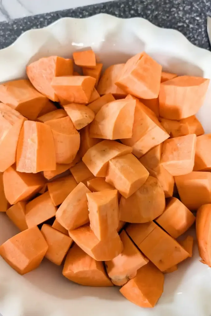 cubed sweet potatoes in white ceramic pie pan