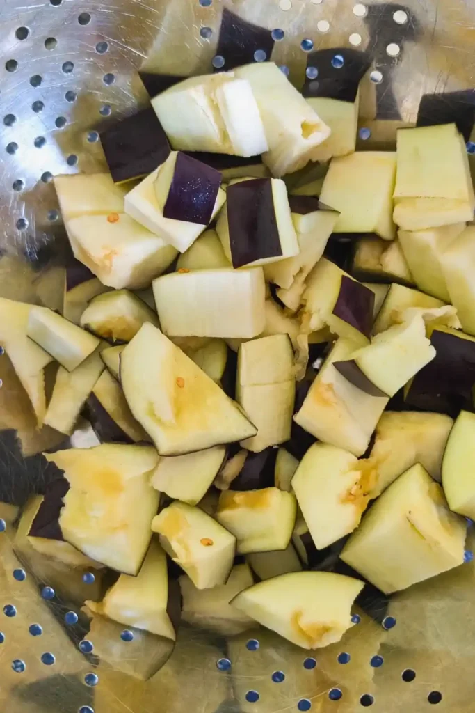 cut up eggplant in colander sweating with salt