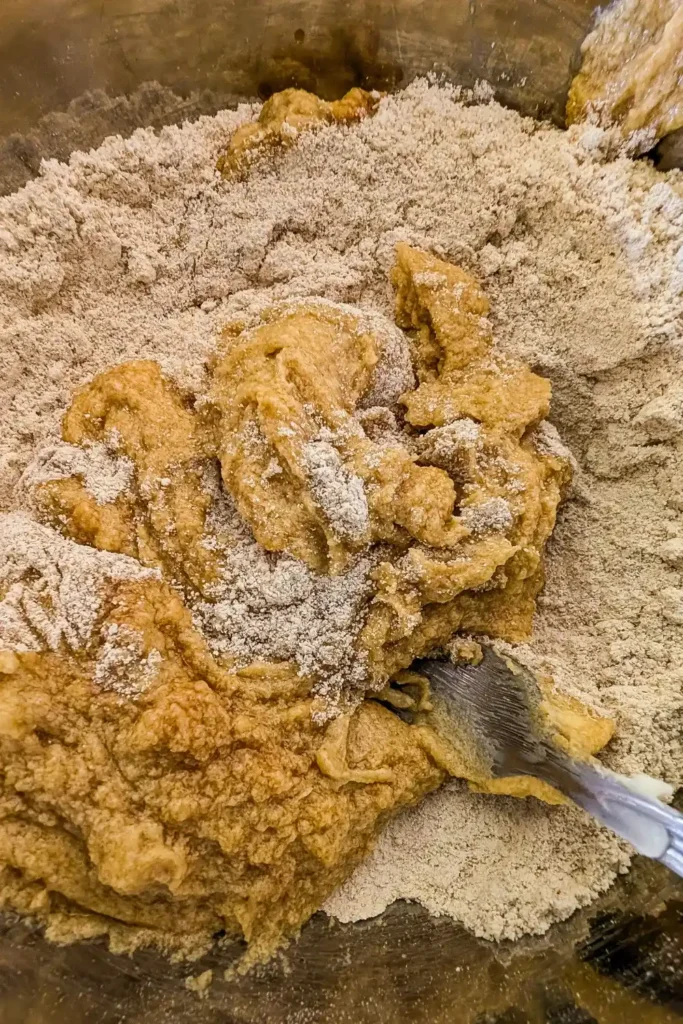 adding wet ingredients to oat flour ingredients in mixing bowl