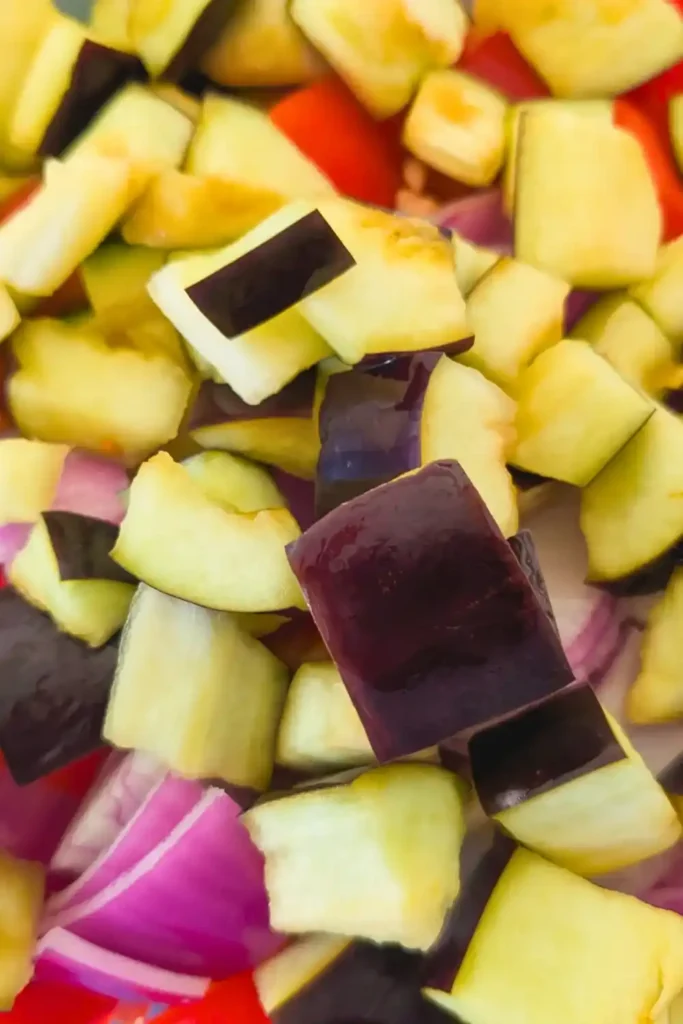 dried eggplant being added to other vegetables in bowl