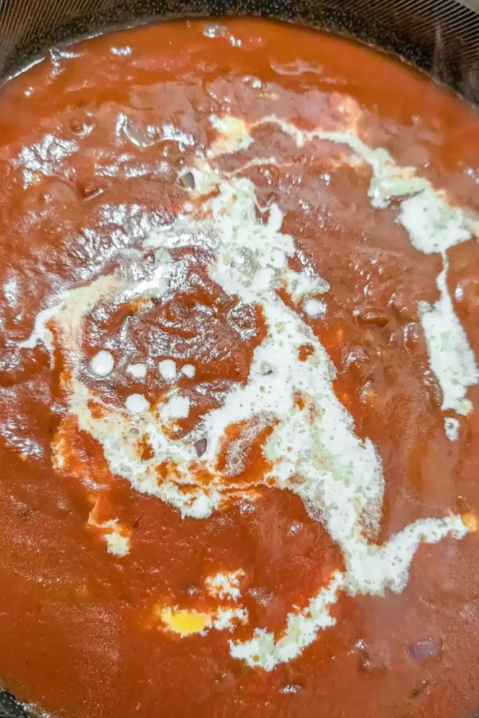 adding tomato sauce and cream to pan