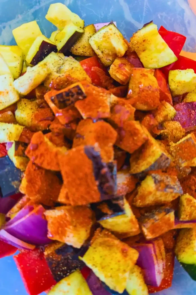 adding paprika and pepper with olive oil to vegetables