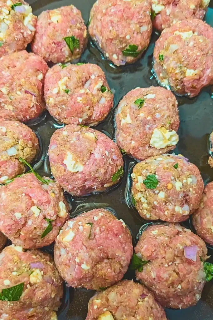 formed raw turkey meatballs in hot oil in pan