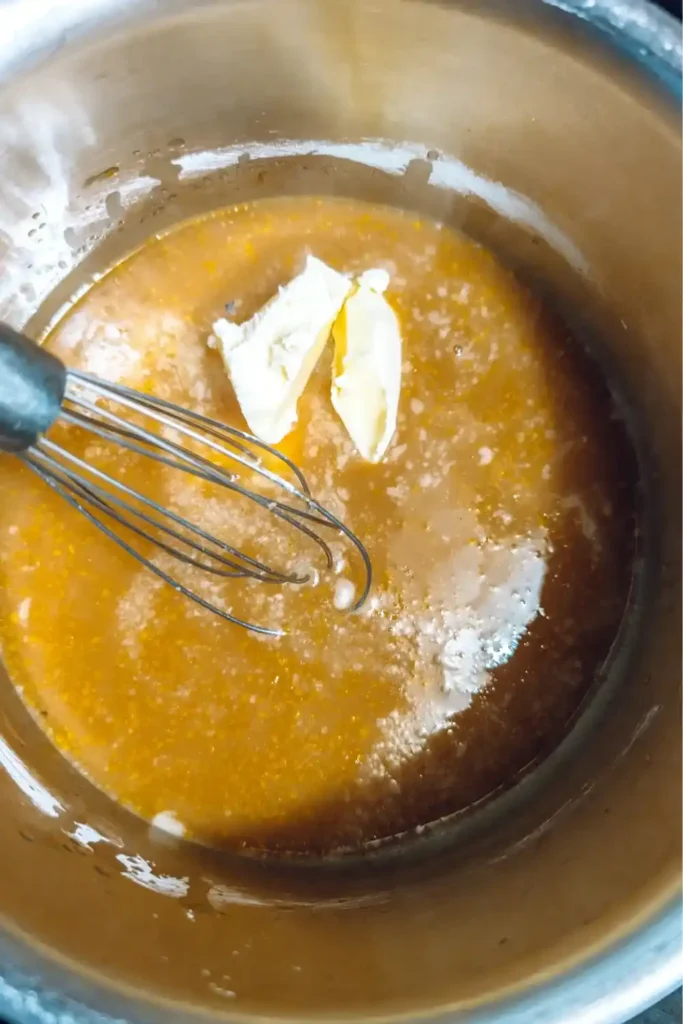 adding butter to orange sauce